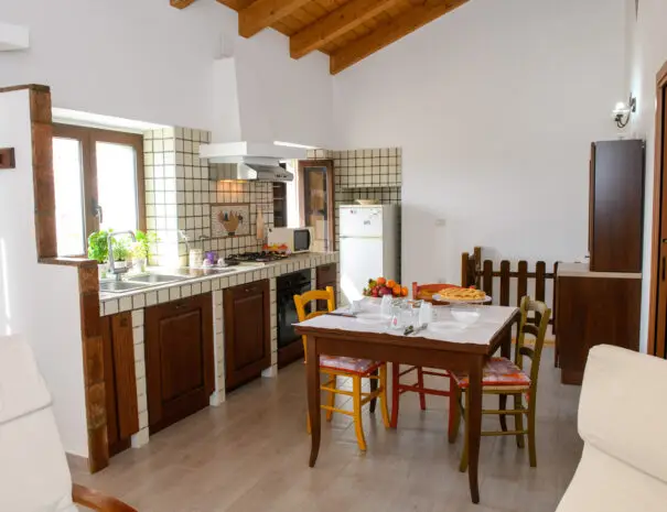 Interno cucina rustica con tavolo da pranzo e dettagli colorati a Nova Siri