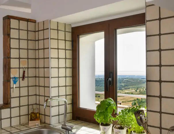 Dettaglio cucina con lavello in acciaio e vista sulle colline della Basilicata
