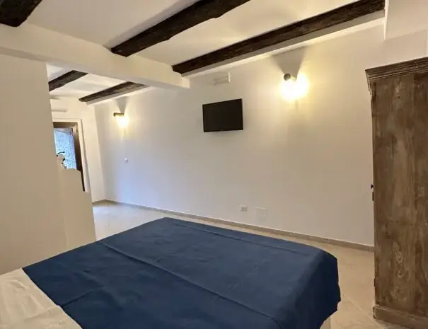 Camera da letto luminosa con arredi minimalisti e travi in legno a Nova Siri