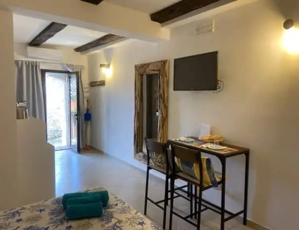 Interno studio moderno con letto matrimoniale e soffitto con travi a vista a Nova Siri