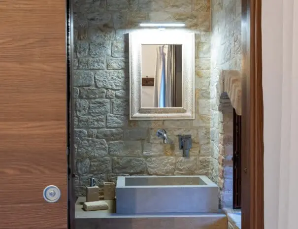 Lavabo in pietra moderna su piano in legno in bagno rustico a Nova Siri