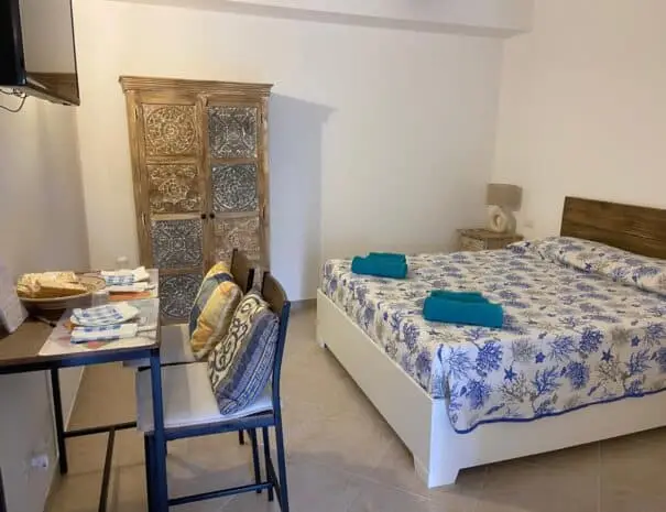 Camera matrimoniale con letto a tema marino e zona pranzo moderna a Nova Siri